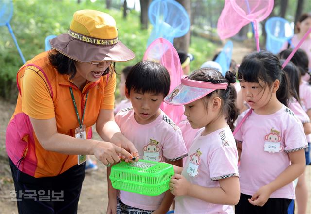 10일 오전 서울 성동구 송정제방 산책로에서 열린 매미학습교실에서 어린이들이 숲해설사의 매미에 관한 설명을 듣고 있다.고영권기자youngkoh@hankookilbo.com