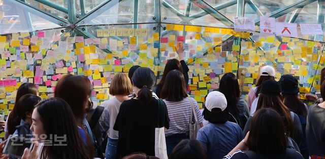 지난 5월 18일 서울 강남역 10번 출구에서 시민들이 살인사건에 희생된 여성을 추모 하는 스티커를 붙이고 있다. 한국일보 자료사진