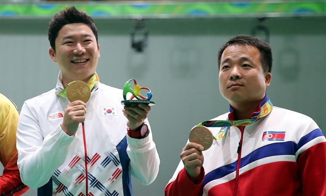 진종오가 11일 브라질 리우데자네이루 올림픽 사격장에서 열린 남자 50m 권총 시상식에서 북한의 김성국과 메달을 들어 보이고 있다. 리우=올림픽사진공동취재단