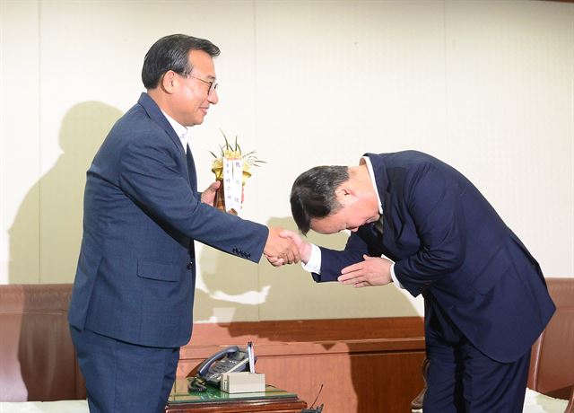 10일 서울 영등포구 새누리당사로 예방 온 김재원(오른쪽) 청와대 정무수석이 이정현 신임 새누리당 대표에게 박근혜 대통령의 축하난을 전하며 넙죽 인사하고 있다. 배우한 기자