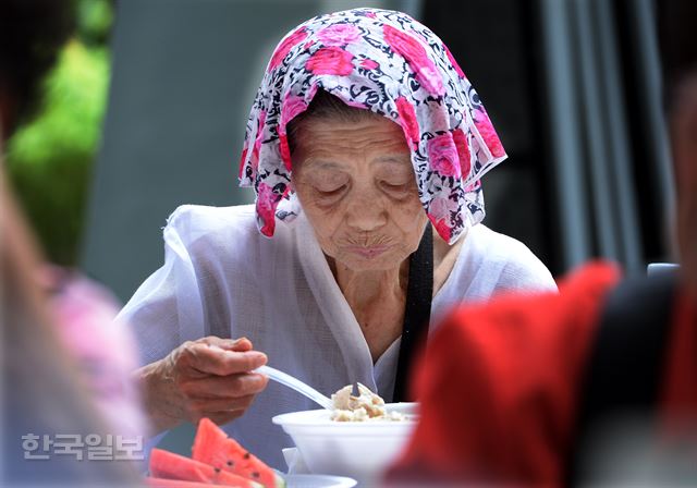 연일 기록적인 더위로 서울과 경기 등 내륙 전 지역에 폭염특보가 발효 중인 11일 오후 서울 중구 장충단공원에서 열린 적십자와 함께하는 건강한 여름나기 삼계탕 데이 행사에 참석한 어르신들이 삼계탕을 드시며 ‘이열치열’로 무더위를 이겨내고 있다.배우한기자 bwh3140@hankookilbo.com