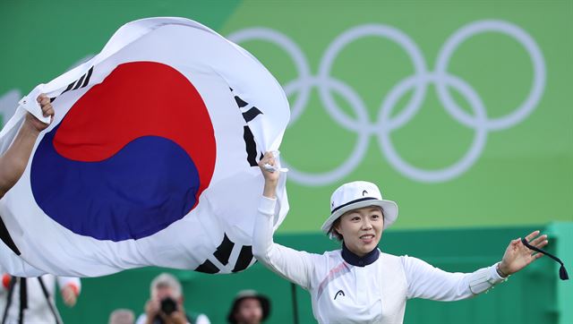 한국 양궁 여자 대표팀의 장혜진이 12일(한국시간) 브라질 리우데자네이루 삼보드로무 경기장에서 열린 양궁 여자 개인전 결승전에서 금메달을 획득한 뒤 태극기를 들고 경기장을 돌고 있다. 리우데자네이루=연합뉴스