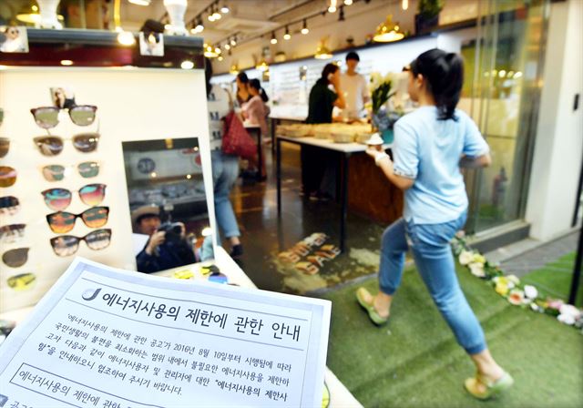 [20160811개문냉방2] 정부가 ‘개문냉방영업’에 대한 단속에 돌입한 11일 서울 명동의 한 상점이 문을 활짝 열어놓은채 에어컨을 가동하고 있다. 배우한기자 bwh3140@hankookilbo.com