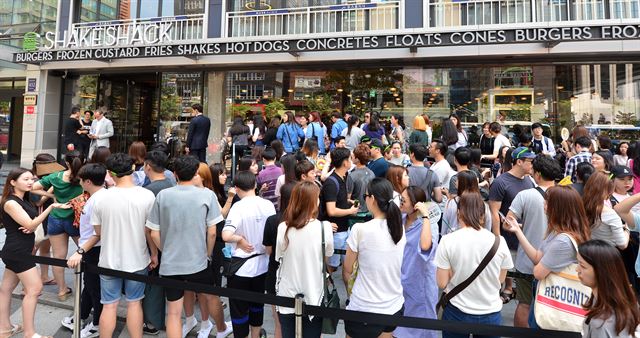 지난달 22일 오전 강남에 1호점을 오픈한 미국의 프리미엄 수제버거 '쉐이크쉑' 매장 앞에 고객들이 몰려들어 붐비고 있다. 뉴스1