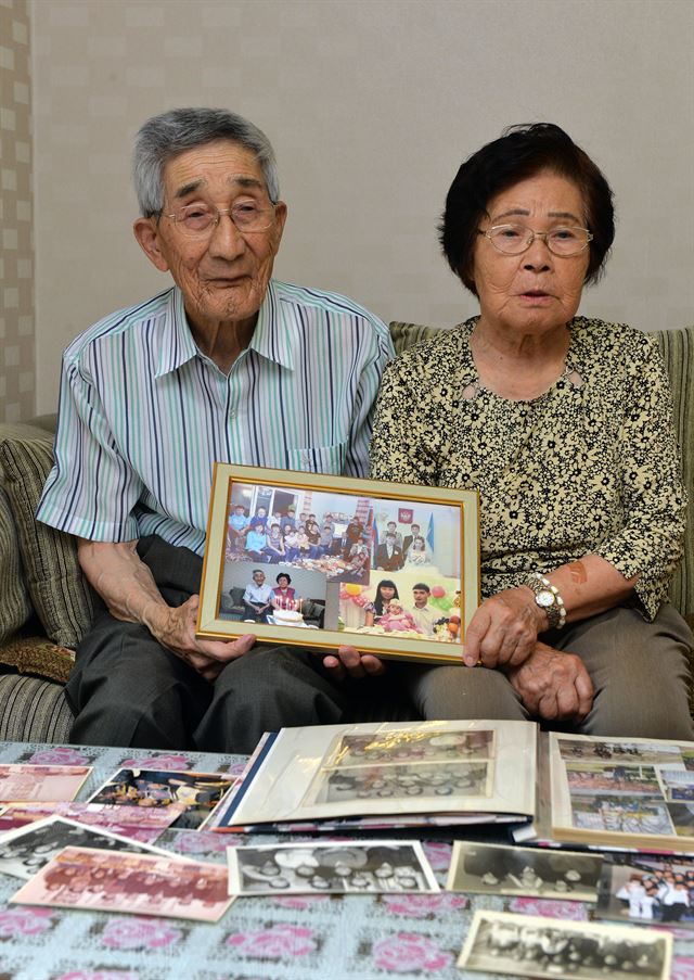 사할린 강제징용 피해자 김정호(94ㆍ왼쪽)씨와 김기와(83)씨 부부가 12일 인천 남동구 논현동 집에서 가족 사진을 들고 힘들었던 과거를 회상하고 있다. 신상순 선임기자ssshin@hankookilbo.com