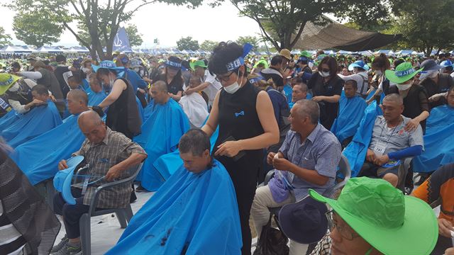 성주와 인근지역 이미용사 150여명이 15일 성주 성밖숲공원에서 성주군민 908명을 단체로 삭발하고 있다. 성주=최홍국기자 hkchoi@hankookilbo.com/2016-08-15(한국일보)