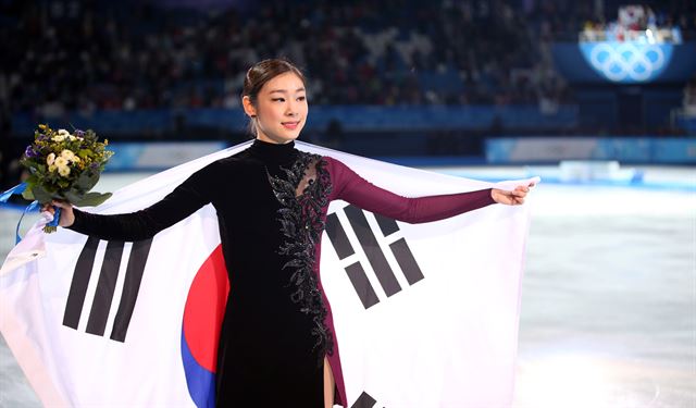 평창동계올림픽을 통해 IOC 선수위원 도전 의사를 밝혀온 김연아의 계획도 차질이 불가피하게 됐다. 사진은 2014년 러시아 소치 동계올림픽에 출전한 김연아가 여자 피겨스케이팅 싱글에서 은메달을 차지한 뒤 태극기를 두른 채 링크를 돌고 있는 모습. 연합뉴스