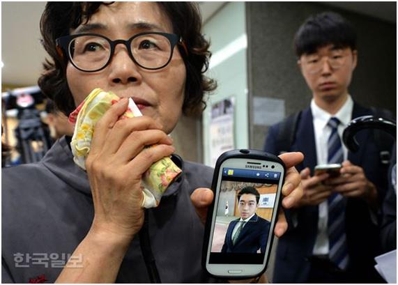 지난 7월5일 오후 서울지방변호사협회에서 사법연수원 41기 동기회 주최로 열린 '김홍영 검사의 죽음에 관한 진상규명과 책임자 처벌 촉구 기자회견'에서 김 검사의 어머니 이기남 씨가 임용 당시의 사진을 공개하고 있다. *아들의 억울한 죽음 뒤에 가려진 진실을 알리겠다는 김 검사 어머니의 뜻을 존중해 고인의 모습은 모자이크 하지 않았습니다.서재훈기자 spring@hankookilbo.com