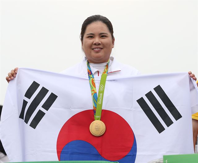 박인비가 20일 오후(현지시간) 브라질 리우데자네이루 올림픽 골프경기장에서 열린 여자 골프 4라운드 경기에서 금메달을 차지했다. 금메달을 목에 건 박인비가 태극기를 들어 보이고 있다 . 리우=올림픽사진공동취재단