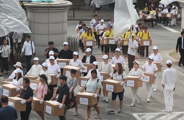 세월호 참사 당시 2학년 학생과 교사들이 사용하던 ‘기억교실’ 임시 이전이 시작된 20일 오후 경기도 안산시 단원고등학교를 출발한 유가족과 자원봉사자들이 아이들 유품이 담긴 상자를 들고 안산교육지원청으로 들어오고 있다. 안산=연합뉴스