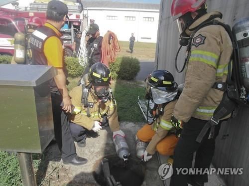 유독가스 질식으로 2명이 숨지고, 1명이 병원 치료를 받는 사고가 발생한 충북 청주시 옥산면 모 유제품 생산공장 내 정화조 입구에서 소방관들이 구조활동을 하고 있다. 연합뉴스