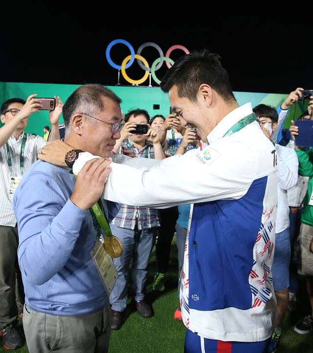 구본찬(오른쪽)이 남자 양궁 개인전에서 우승한 뒤 정의선 양궁협회장에게 금메달을 걸어주고 있다. 리우=올림픽사진공동취재단