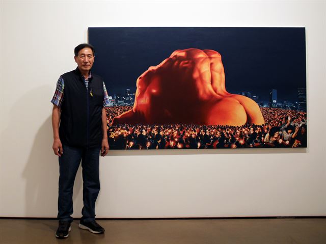 한국 민중미술을 대표하는 신학철 작가가 18일 학고재갤러리에 전시된 자신의 작품 ‘한국현대사-광장’ 앞에 서 있다. 학고재갤러리 제공