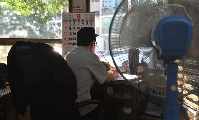 연일 기록적인 폭염이 이어지고 있는 가운데 서울 시내에 위치한 아파트 단지 경비실에서 경비원이 선풍기 한 대에 의지한 채 업무를 보고 있다. 뉴시스