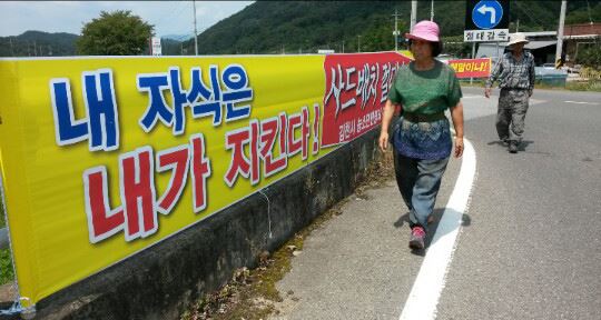 22일 경북 김천시 농소면 도로변에서 주민들이 사드배치에 반대하는 플래카드를 보며 지나가고 있다. 추종호기자 choo@hankookilbo.com