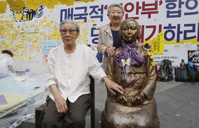 지난 14일 오후 서울 종로구 중학동 주한 일본대사관 앞에서 '세계 일본군 위안부 기림일'을 맞아 열린 '나비 문화제'에 참석한 김복동 할머니가 소녀상 옆 빈 의자에 앉아있다. 오른쪽은 길원옥 할머니. 연합뉴스