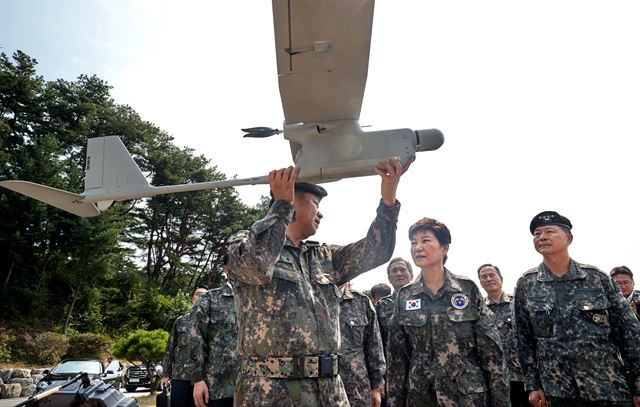 박근혜 대통령이 24일 한미 연합 을지프리덤가디언(UFG) 연습이 한창인 강원 춘천의 육군 제2군단을 찾아 무인항공기에 대한 설명을 듣고 있다. 이날 북한이 발사한 잠수함탄도미사일(SLBM)이 500여km를 날아가 실전배치가 임박하면서 군사적 긴장이 고조됐다. 앞줄 왼쪽부터 김운용 2군단장, 박 대통령, 장준규 육군참모총장. 청와대 제공