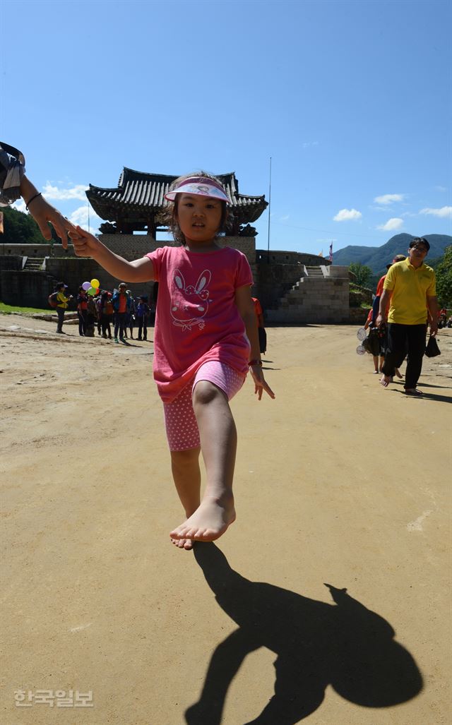 /27일 경북 문경새재에서 대구한국일보사 주최로 열린 ‘2016 문경새재 맨발페스티벌’에서 한 어린이가 ‘영남제일관’을 지나며 맨발을 들어보이고 있다. 신상순 선임기자 ssshin@hankookilbo.com