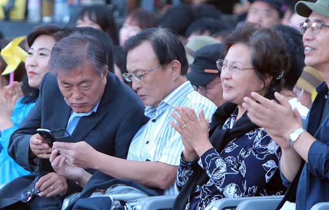 27일 오후 경남 김해시 봉하마을 대통령 묘역 인근 문화생태공원에서 열린 노무현 전 대통령 탄생 70주년 봉하 음악회 도중 문재인 전 더민주 대표(왼쪽)와 이해찬 노무현재단 이사장(오른쪽)이 스마트폰을 보고 있다. 이해찬 이사장 옆은 권양숙 여사, 유시민 전 장관. 봉하=연합뉴스