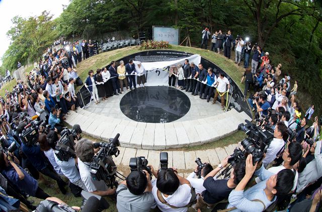 29일 오후 서울 중구 예장동 남산공원 통감관저터에서 열린 일본군 위안부 피해자 '기억의 터' 제막식에서 참가자들이 '대지의 눈'의 가림막을 걷어내고 있다. 연합뉴스