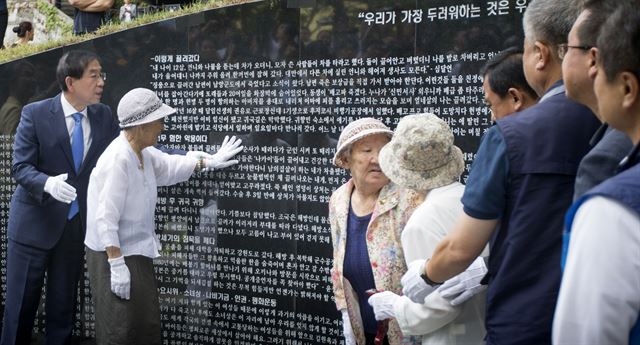 일본군 위안부 피해자 `기억의 터' 제막식이 열린 29일 오후 서울 중구 예장동 남산공원 통감관저터에서 위안부 피해자 김복동, 길원옥 할머니와 박원순 시장 을 비롯한 참석자들이 피해자 247명의 이름이 새겨진 임옥상 작가가 만든 조형물 `대지의 눈'을 바라보고 있다. 뉴시스