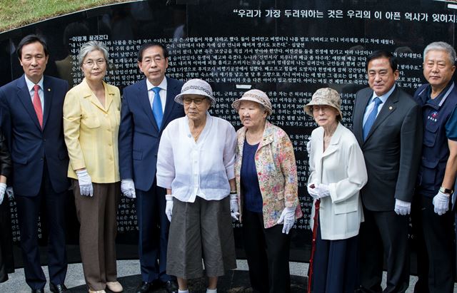 29일 오전 서울 남산 옛 통감관저터에 열린 일본군 '위안부' 기억의 터 제막식에 참석한 김복동, 길원옥 할머니와 참석자들이 조형물 '대지의 눈' 앞에서 기념촬영을 하고 있다. 왼쪽부터 우상호 더불어민주당 원내대표, 최영희 기억의 터 추진위원장, 박원순 서울시장, 김복동, 길원옥, 양준욱 서울시의장, 김동만 한국노총위원장. '기억의 터'에는 위안부 피해 할머니 247명의 성함과 증언을 시기별로 새긴 '대지의 눈'과 "기억하지 않는 역사는 되풀이 된다"/그림 5 29일 오후 서울 중구 예장동 남산공원 옛 통감관저터에서 열린 일본군 위안부 '기억의 터' 제막식에 김복동 할머니가 참석하고 있다.2016.8.29/뉴스1