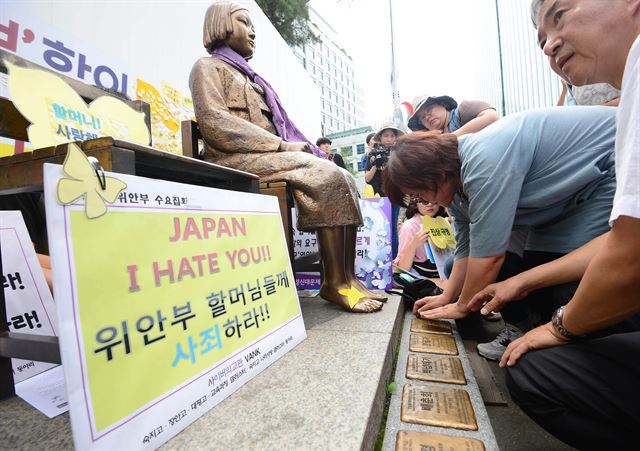 지난달 20일 서울 종로구 주한일본대사관 앞에서 열린 '1240차 일본군 위안부 문제해결을 위한 정기 수요시위'에 참석한 평화의 소녀상 작가 김서경씨가 일본군위안부 피해 할머니들의 이름이 새겨진 동판을 붙이는 퍼포먼스를 하고 있다. 서재훈기자 spring@hankookilbo.com