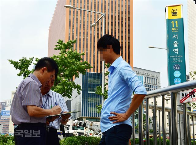 지하철 출입구 10m 이내 흡연시 과태료가 부과되는 1일 오후 서울 서울역 지하철 입구에서 구청직원이 단속을 실시하고 있다. 홍인기 기자