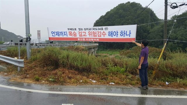 경북 안동시 풍산읍 주민들이 현수막을 걸고 국도 34호선 상리교 대체도로 건설을 촉구하고 있다. 풍산읍 제공