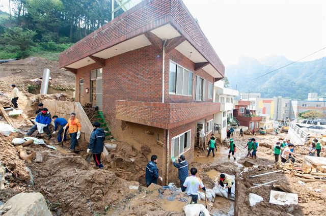 폭우로 산사태가 발생한 경북 울릉군 울릉읍 도동리 LH임대주택 건설현장 인근 주택가에서 1일 울릉도 주민들이 복구 작업을 펼치고 있다. 울릉군 페이스북.