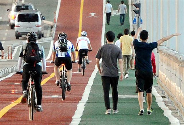 자전거 전용도로가 설치가 된 서울 잠수교에서 자전거 이용자와 보행자들이 나란히 이동하고 있다. 한국일보 자료사진