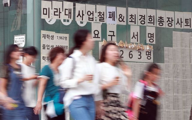 여름방학을 마치고 1일 개강한 서울 이화여대에서 등교한 학생들이 미래라이프대학설립 반대 및 총장사퇴 등의 문구가 적힌 게시물 앞을 지나고 있다 . 연합뉴스