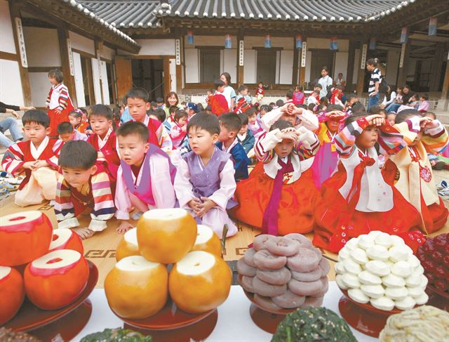 추석을 앞두고 서울 필동 남산한옥마을에서 어린이들이 추석 차례상에 절하는 법을 배우고 있다. 한 상 가득 차려진 과일과 음식들은 오래 전부터 '풍성한 한가위'의 상징이었다. 한국일보 자료사진