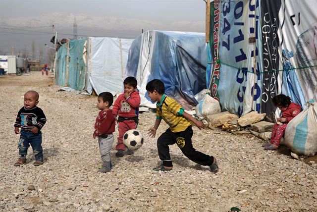 유엔아동기금(UNICEF·유니세프)가 보고서를 통해 전 세계 어린이 5천만 명이 삶의 터전을 잃었고 이 가운데 2천800만 명은 외부의 분쟁으로 강제로 고향을 떠난 상태에 놓여 있다고 밝힌 가운데 사진은 지난 1월 22일(현지시간) 레바논의 베카밸리의 난민캠프 앞에서 시리아 난민 어린이들이 축구공을 차며 놀고 있다. AP 연합뉴스