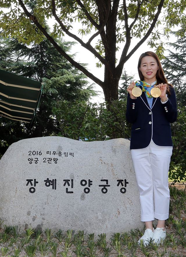 장혜진 선수가 '장혜진 양궁장'으로 명명된 계명대 양궁장 앞에서 금메달 2개를 들어 보이고 있다. 계명대 제공