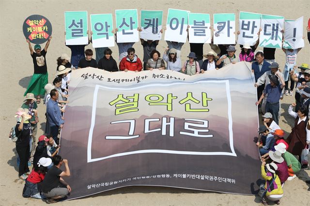 설악산 오색 케이블카 설치에 반대하는 전국 활동가들이 지난 1일 강원 양양군 낙산해변에서 사업 철회를 요구하는 집회를 갖고 있다. 뉴시스