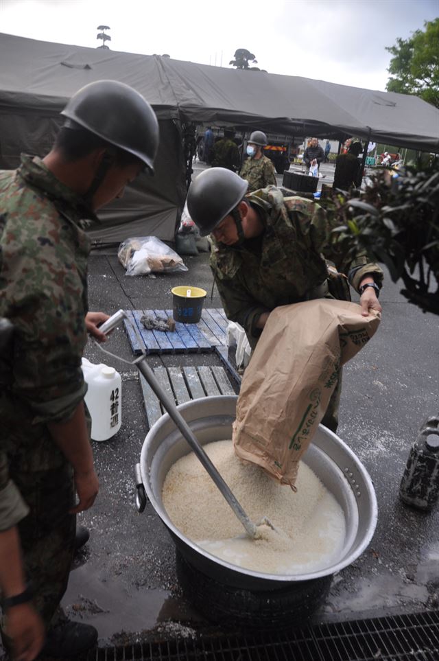 지난 4월 일본 구마모토현 마시키마치 마을회관 앞에서 지진피난민들을 위해 긴급식량 배급을 준비하는 자위대원들. 구마모토=박석원특파원