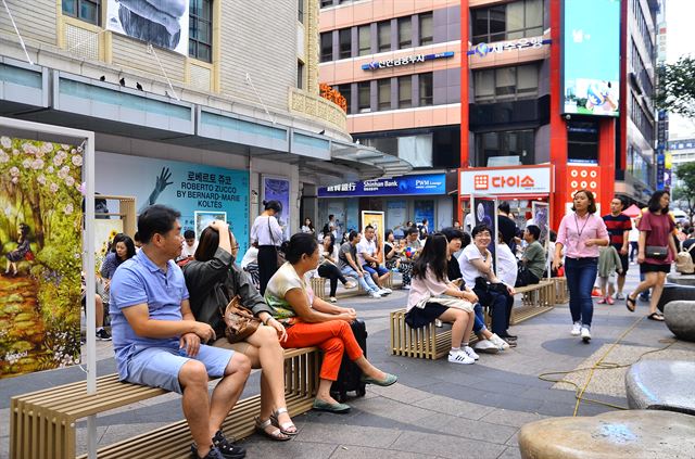 명동예술극장 앞 의자에서 사람들이 잠시 휴식을 취하고 있다.