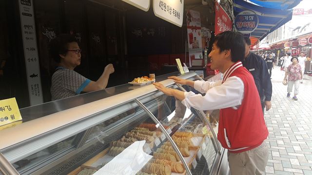 부산 해운대갑이 지역구인 하태경 새누리당 의원이 14일 부산 해운대 전통시장에서 한 상인에게 추석 인사를 건네고 있다. 하태경 의원실 제공