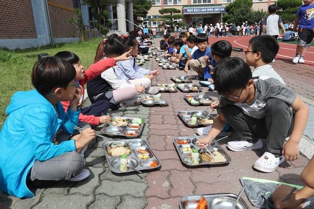 경북 경주시 불국사초등학교 학생들이 21일 점심 직전 여진이 발생하자 모두 운동장으로 대피한 뒤 보도블럭에 쭈그리고 앉아 급식을 먹고 있다. 경주=연합뉴스