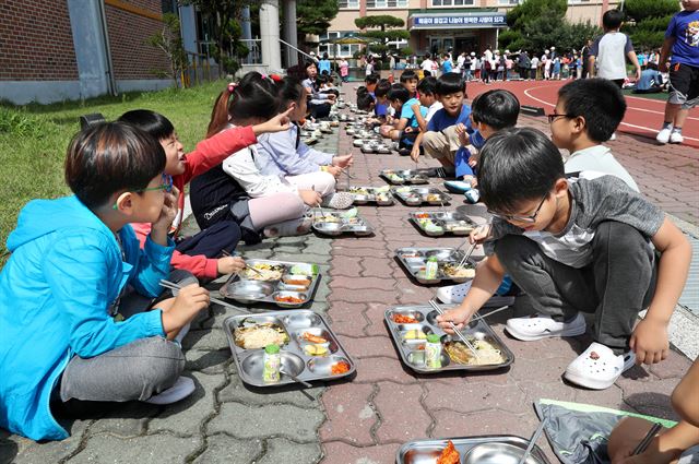 경북 경주시 불국사초등학교 학생들이 21일 점심 직전 여진이 발생하자 모두 운동장으로 대피한 뒤 줄지어 쭈그려 앉아 급식을 먹고 있다. 경주=연합뉴스