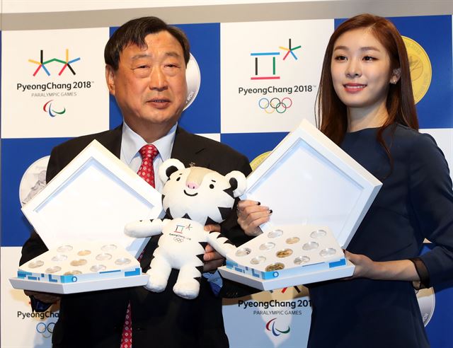 이희범(왼쪽) 평창동계올림픽 조직위원장과 김연아가 22일 오전 서울 서대문구 풍산빌딩에서 열린 2018 평창 동계올림픽대회 기념주화 공개 발표회에서 기념주화를 들고 포즈를 취하고 있다. 연합뉴스