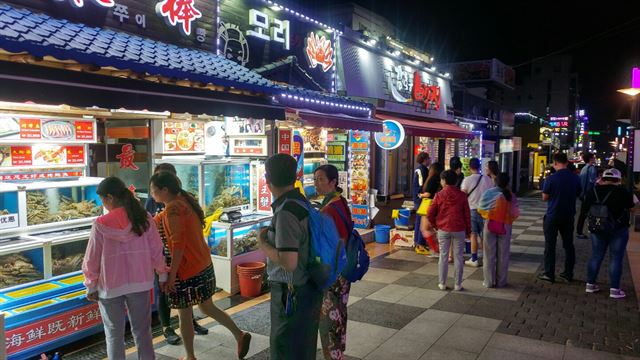 중국 관광객들이 주말인 23일 삼삼오오 모여 제주 속 작은 중국이라 불리는 제주시 연동 ‘바오젠 거리’를 둘러보고 있다. 지난 17일 발생한 제주 성당 살인사건 이후 경찰의 순찰이 강화되면서 중국인 이주민과 불법체류자의 발길은 크게 줄었다. 제주=김영헌 기자