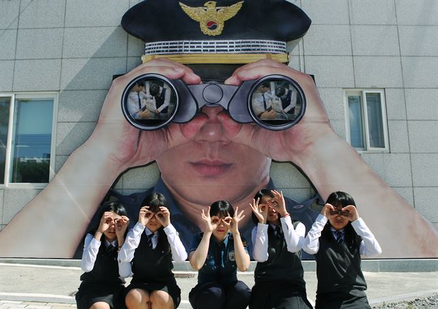 여학생들이 대구 수성구 만촌동 대구 수성경찰학교 외벽에 설치된 쌍안경 앞에서 익살스런 표정을 짓고 있다. 대형 쌍안경은 대구경찰이 학교폭력을 샅샅히 살펴 예방하는 경찰관의 모습을 형상화했다. 대구지방경찰청 제공