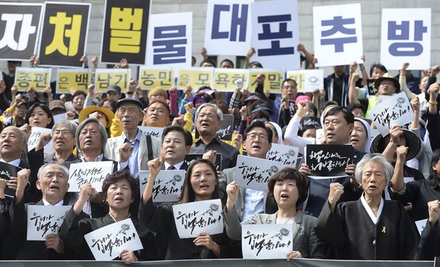 고 백남기 농민 유가족들과 백남기 투쟁본부 회원들이 29일 오전 서울 종로구 세종문화회관 중앙계단에서 열린 '백남기 농민 사망 국가폭력 규탄 시국선언'에서 정부의 사죄, 부검 시도 즉각 중단, 국가폭력 종식과 물대포 추방 등을 요구하는 구호를 외치고 있다. 뉴스1