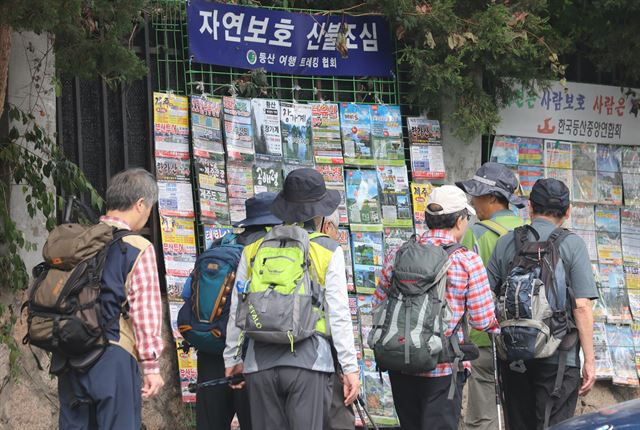 김영란법 시행 첫 주말인 1일 오전 시민들이 북한산 인근에 붙은 산행 광고물앞을 지나고 있다. 등산로에서는 김영란법 관련 대화들이 종종 들렸다. 한편 이날 강원도 설악산 등은 단풍객으로 북적인 반면 도내 골프장은 평소 주말보다 10∼20％가량 고객이 줄은 것으로 전해졌다. 연합뉴스