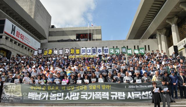 지난달 29일 서울 종로구 세종문화회관 계단에서 열린 '백남기 농민 사망 국가폭력 규탄 시국선언'에서 참가자들이 시국선언문을 낭독하고 있다. 신상순 선임기자 ssshin@hankookilbo.com