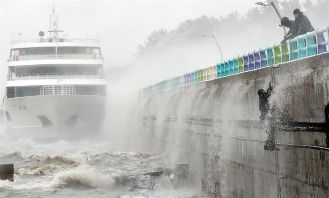 제18호 태풍 '차바'가 북상한 5일 오전 전남 여수시 오동도 방파제에 여객선이 좌초해 물에 빠진 선원을 해경이 구조하고 있다. 여수=연합뉴스