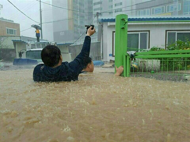 태풍 '차바'의 영향으로 울산 시내가 물에 잠긴 5일, 중구 태화동의 한 거리에서 주민들이 겨우 걸어서 안전한 곳으로 걸어가고 있다. 연합뉴스