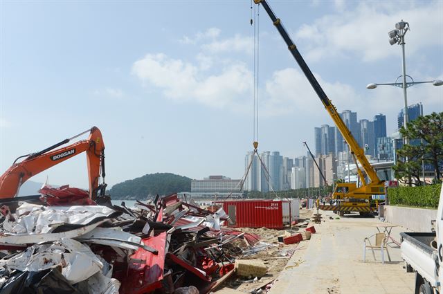 제21회 부산국제영화제 개막식이 열리는 6일 오전 부산 해운대해수욕장에서 태풍으로 부서진 비프빌리지를 포크레인이 철거하고 있다. 부산=전혜원 기자 iamjhw@hankookilbo.com